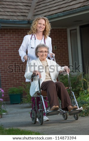 Home Care Nurse Pushing Senior on Wheelchair Outdoor in Early Morning