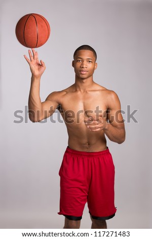 Young Black College Student Holding Basket Ball on Grey Background