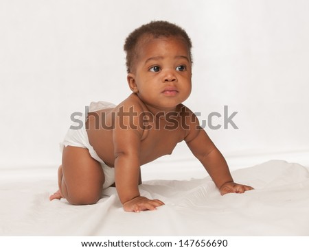 3-month old African American baby boy crawling on the bed