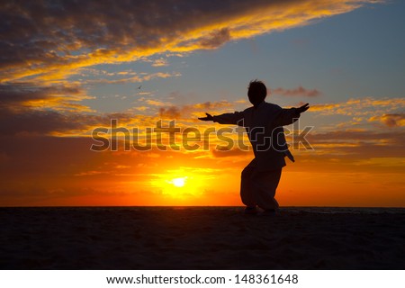 Chinese Elderly Woman Performing Taichi Outdoor by the beach under sunset sunrise silhouette