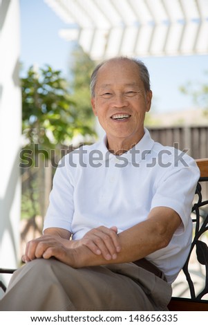 Happy Smiling Asian Senior Elderly Sitting at Backyard