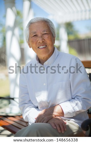 Happy Asian Senior Woman Siting at Backyard  Outdoor Portrait