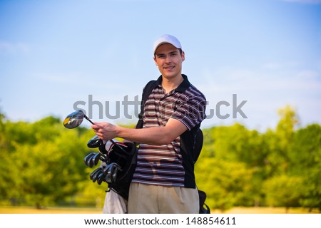 Young Golfer Ready to Swing Club Early Morning  under Summer Blue Sky