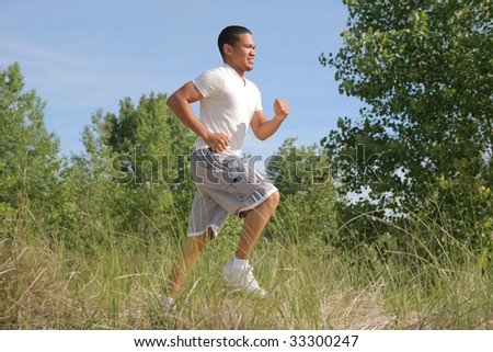 Healthy Looking Young Man Jogging in the Woods