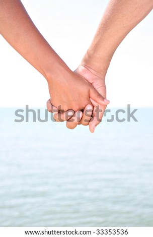 stock photo : Two Young People Holding Hands with Water as Background
