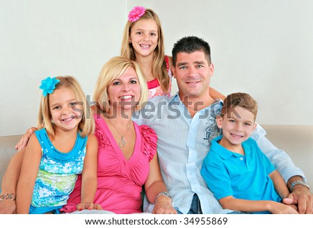 Family Group of Five Portrait Sitting on Sofa Indoor