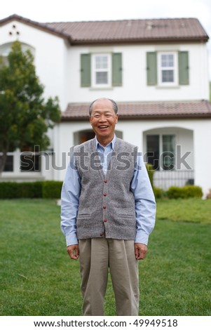 Happy Smiling Chinese Elderly Standing in front of New House