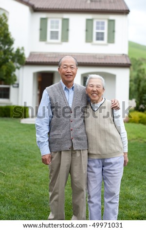 Happy Smiling Chinese Elderly Standing in front of New House