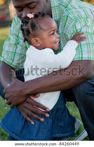 Little Smiling African American Girl Hugging Dad Outdoor