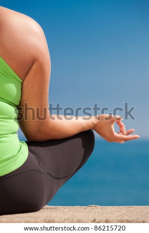 Plus size female practice yoga outdoor under blue sky