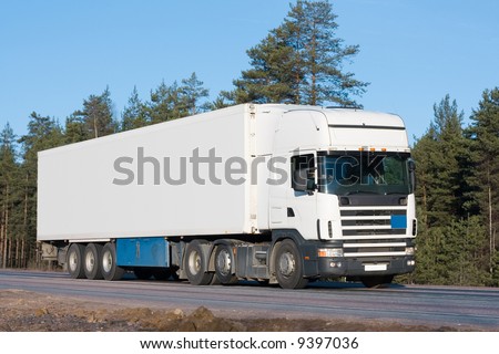 tractor trailer truck on background of trees of \