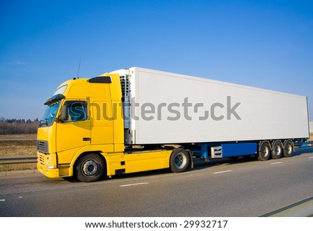 Yellow white blank truck on a country road