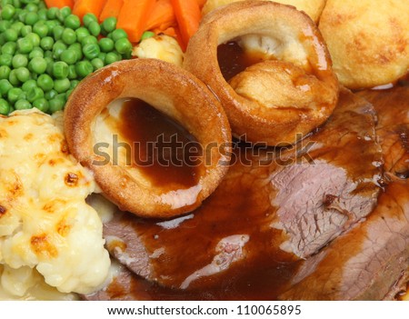 Traditional Sunday roast beef dinner with Yorkshire puddings and gravy.