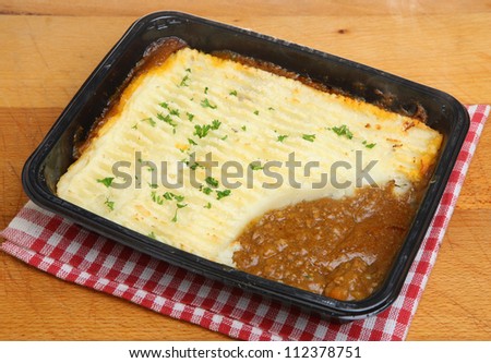 Shepherds pie convenience food in plastic tray with steam rising.