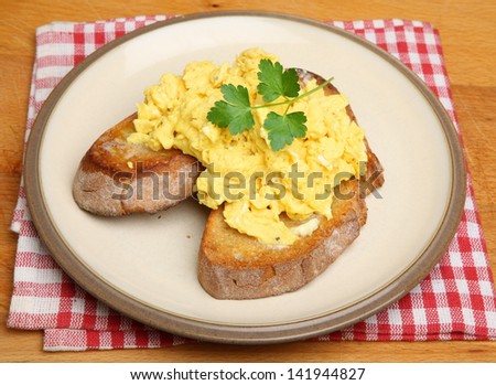 Scrambled eggs on toasted artisan bread.
