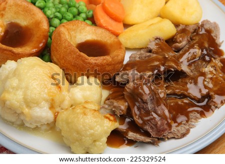 Traditional Sunday roast dinner with Yorkshire puddings and gravy.