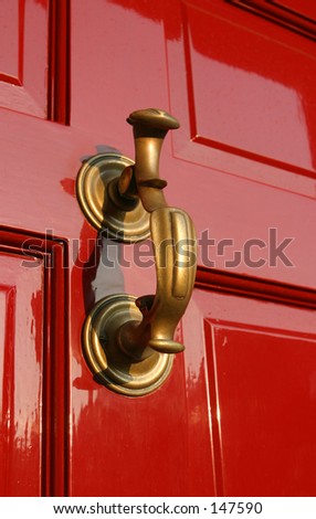 Georgian Door Knocker on burgundy paneled wooden door.