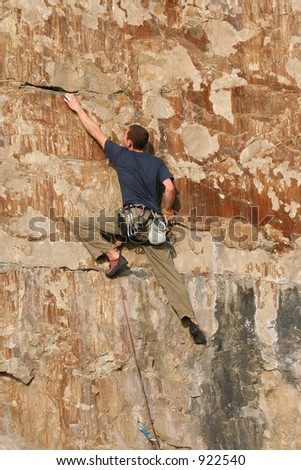 Rock climber ascending sheer cliff face