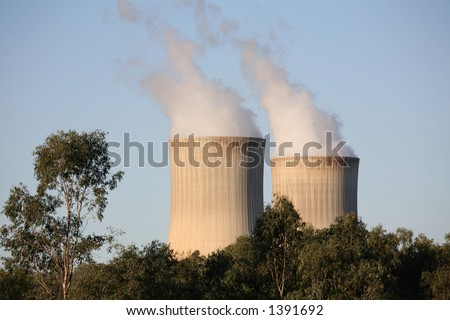Power station cooling towers amidst trees __ focus on towers