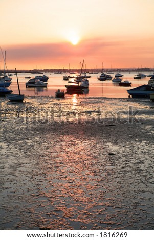 Sunset at low tide, Poole Harbour, Dorset. Focus on foreground mud with room for text.