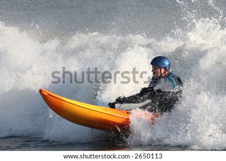 Kayaker surfing through rough seas
