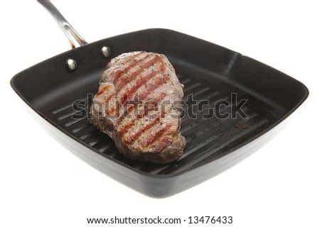 Sirloin steak frying in a griddle pan