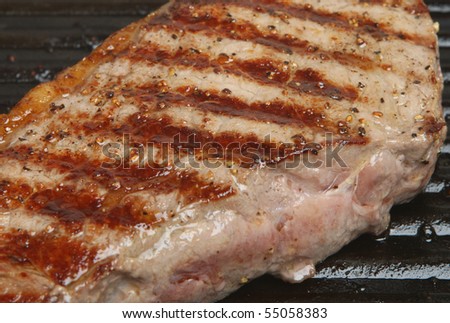 Seared steak in griddle pan.