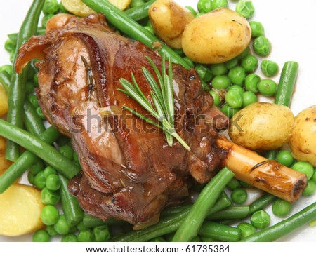 Roast lamb shank with new potatoes, peas and green beans.