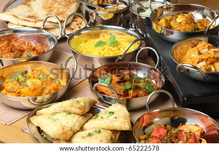 stock photo : Selection of Indian food including curries, rice, samosas and naan bread.