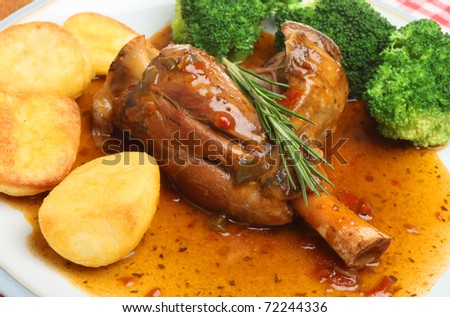 Slow-cooked lamb shank with roast potatoes and broccoli.