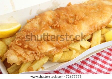 Fried cod & chips in cardboard takeaway carton.