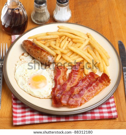 Sausage, bacon, fried egg and french fries
