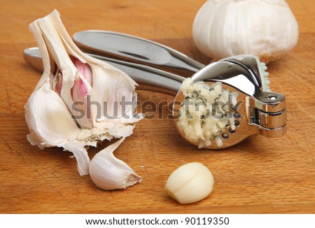 Garlic press with crushed bulb.