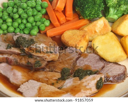 Sunday roast lamb dinner with mint sauce.