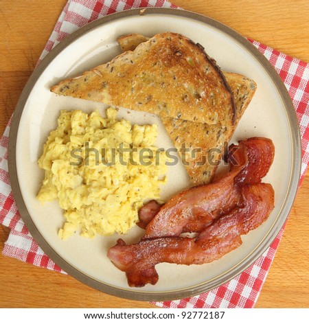 Scrambled eggs, bacon and buttered toast.