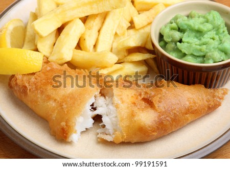 Fried cod fillet with chips and mushy peas. Shallow DoF, focus on the fish.