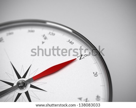 Measure instrument, compass with red needle pointing to the north. Blur effect focus on the letter N. Grey background