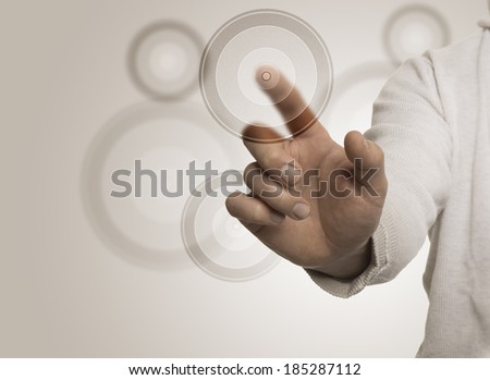 Man hand touching a transparent target with the index, beige background. Image suitable for a Marketing Concept or Business solutions with free space for text on the left
