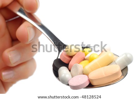 Doctor male hand with spoon of pills vitamins tablets drugs isolated over white