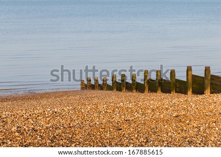A wooden water-break on a pebble beach