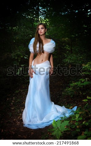 beautiful fairy girl in light blue dress in forest