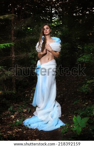 beautiful fairy girl in light blue dress in forest