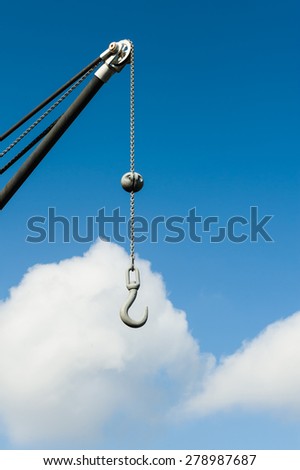 Metal hook hanging on a chain.