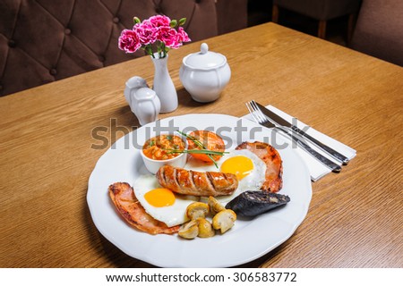 Full English breakfast with egg, bacon, beans, sausage, mushrooms and tomato.