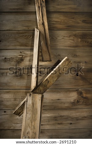 Close up of side of rustic wooden building with wood pieces hanging down.