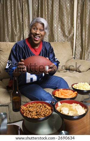 Portrait of smiling Middle-aged African-American woman wearing jersey and holding football.