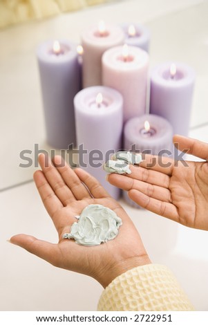 Asian/Indian young womans hands with facial scrub.