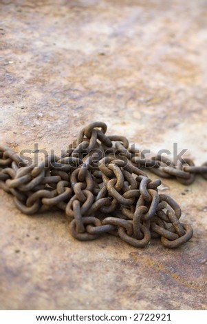 Pile of rusty chain on rusty metal.