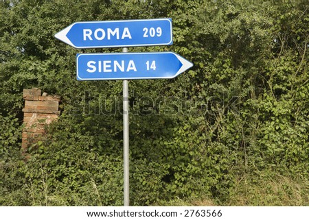 Italian street signs with overgrown vegetation pointing to Rome and Siena.