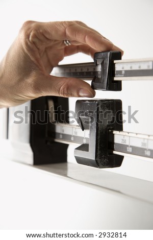 Close-up of female\'s hand reading her weight on scale.